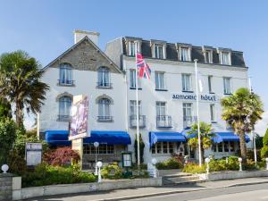 un bâtiment blanc arborant un drapeau américain devant lui dans l'établissement L'Armoric Hôtel, à Bénodet