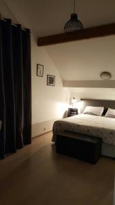 a bedroom with a bed and a pendant light at Paris Côté Jardin in Chalifert