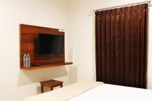 a bedroom with a bed and a tv on a wall at House of Dharmawan in Surabaya
