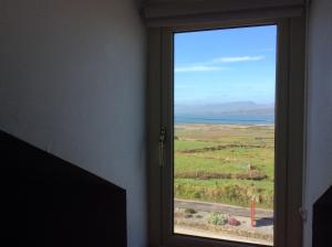 - une fenêtre dans une chambre avec vue sur l'océan dans l'établissement Cappa House B&B, à Eyeries