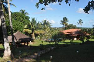 een uitzicht op een resort met palmbomen en een gebouw bij Sitiopousada. " Os Tres " in Camaçari