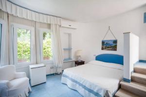 una camera con letto, sedia e finestre di "Mbriacate' e Sole" at 5 minutes from the beach! a Ischia