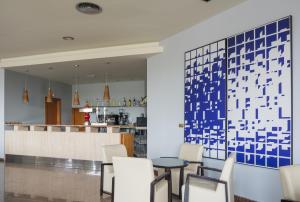 un restaurant avec des chaises blanches et un mur bleu dans l'établissement Royal Costa, à Torremolinos