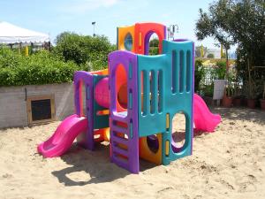 un parque infantil con un equipo de juegos en la arena en Hotel Sirenetta, en Lido di Jesolo