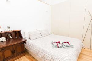 a bedroom with a bed with towels and shoes on it at Our Home City Flat in Porto