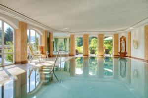 una piscina cubierta en una casa con ventanas en DIANA Naturpark Hotel - mit Oberstaufen Plus Golf, en Oberstaufen