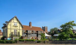 a yellow building with a sign that reads durhamrences at Ogilvie Lodge Apartment in Thorpeness