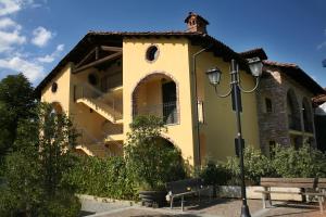 un edificio giallo con una scala sul lato di Hotel Barolo a Barolo