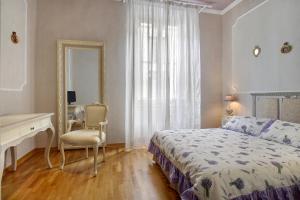 フィレンツェにあるAppartamento Montanelliのベッドルーム(ベッド1台、デスク、鏡付)