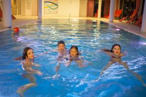 a group of children swimming in a swimming pool at Hotel Amadeus Micheluzzi in Serfaus