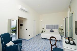 a hotel room with a bed and a chair at Hotel Aurora in Amalfi