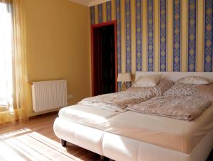 ein Schlafzimmer mit einem Bett mit einer blauen und gelben Wand in der Unterkunft Lakeside Luxury Apartment in Zamárdi