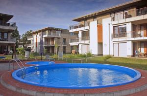 a pool in a courtyard in front of a building at Lakeside Luxury Apartment in Zamárdi
