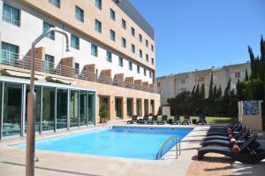 a swimming pool in front of a building at Hotel Real Oeiras in Oeiras