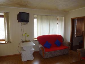 SalavatにあるМини Отель Советскийのリビングルーム(赤い椅子、テレビ付)