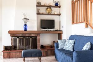 ein Wohnzimmer mit einer blauen Couch und einem Kamin in der Unterkunft Villa Tina in Santa Maria di Castellabate