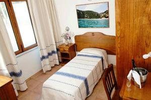 1 dormitorio con cama, mesa y ventana en Bellamarina, en Sorso