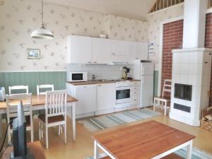 een keuken met witte kasten en een tafel en een eetkamer bij Seilorin Lomakylä in Luvia