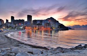 カーラ・デ・フィネストラットにあるApartamentos Ocañaの夕日時の市街とビーチの景色
