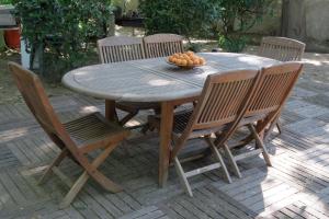 uma mesa de madeira com cadeiras e uma taça de fruta em Le Domaine de Fraissinet em Ouveillan