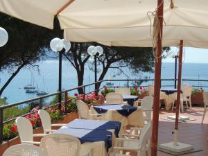a patio with tables and chairs and the ocean at Hotel Viticcio in Portoferraio