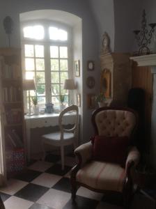 een woonkamer met een stoel en een raam bij Le petit Figuier in La Roque-dʼAnthéron