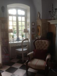 a living room with a chair and a window at Le petit Figuier in La Roque-dʼAnthéron