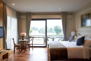 Pokój hotelowy z łóżkiem i balkonem w obiekcie L'air Du Pran w mieście Pran Buri