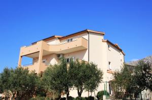 a building with trees in front of it at Priska Apartment in Kaštela