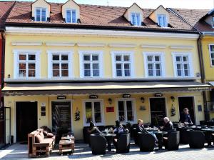 un groupe de personnes assis à des tables à l'extérieur d'un bâtiment dans l'établissement Regal Residence B&B, à Zagreb