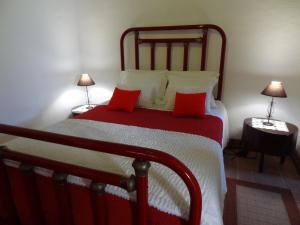 a bedroom with a large bed with red pillows at Casa do Rei in Furnas