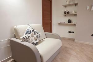 una silla blanca con una almohada en una habitación en Amira Luxury Apartments, en Santa Maria Capua Vetere