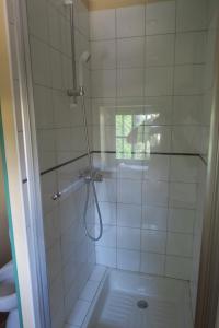 baño con ducha y puerta de cristal en Le Domaine de Fraissinet, en Ouveillan