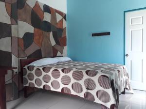 a bedroom with a bed with a colorful wall at Nacientes Lodge in Bijagua