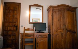 
a room with a wooden cabinet and a wooden table at Hotel Santa Isabel in Toledo
