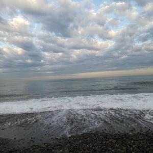 a beach with a cloudy sky and the ocean at Guest House Batumi in Batumi