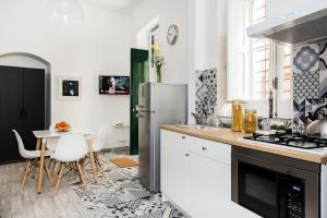 a white kitchen with a table and a refrigerator at Casa Nerina in Scicli