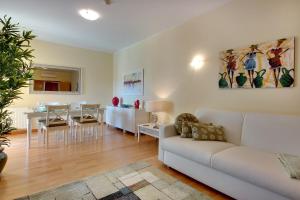 a living room with a white couch and a dining room at Marina Coast Residence in Albufeira