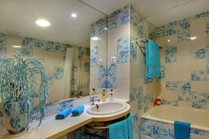 a bathroom with blue tiled walls and a sink and a tub at Marina Coast Residence in Albufeira +12 photos