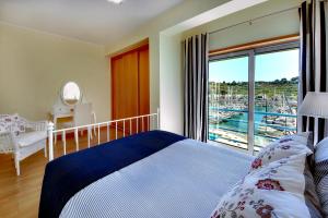 a bedroom with a bed and a balcony with a view at Marina Coast Residence in Albufeira