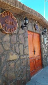 a sign on the side of a stone building at Hostal Casa Flores in San Pedro de Atacama