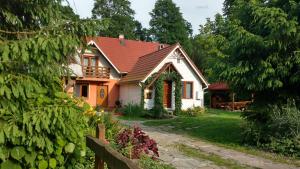a small white house with a red roof at Rodzinny Domek Apartament in Wisłoczek