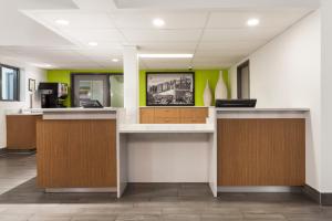 an office with two reception desks and green walls at Super 8 by Wyndham Winnipeg West in Saint James +66 photos