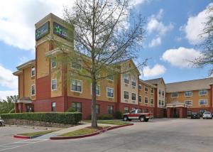un grand bâtiment avec un arbre en face dans l'établissement Extended Stay America Suites - Fort Worth - City View, à Fort Worth