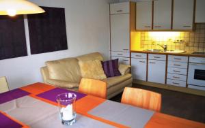 a living room with a table and a couch and a kitchen at Ferienwohnung Strubbauer Urlaub am Bauernhof in Abtenau