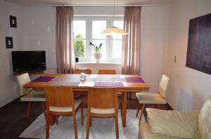 a dining room with a wooden table and chairs at Ferienwohnung Strubbauer Urlaub am Bauernhof in Abtenau