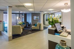 an office lobby with a desk with a computer and flowers at The Voyager Inn in Anchorage