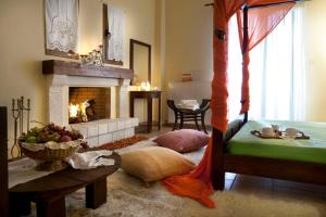 a living room with a bed and a fireplace at Agnantio studios & suites in Lagadia