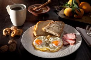 a plate of food with eggs and bread and a cup of coffee at Agnantio studios & suites in Lagkadia