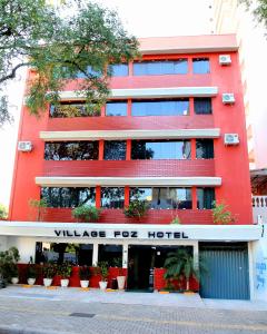 un edificio rojo con un letrero que lee pueblo para hotel en Hotel Village Foz, en Foz do Iguaçu